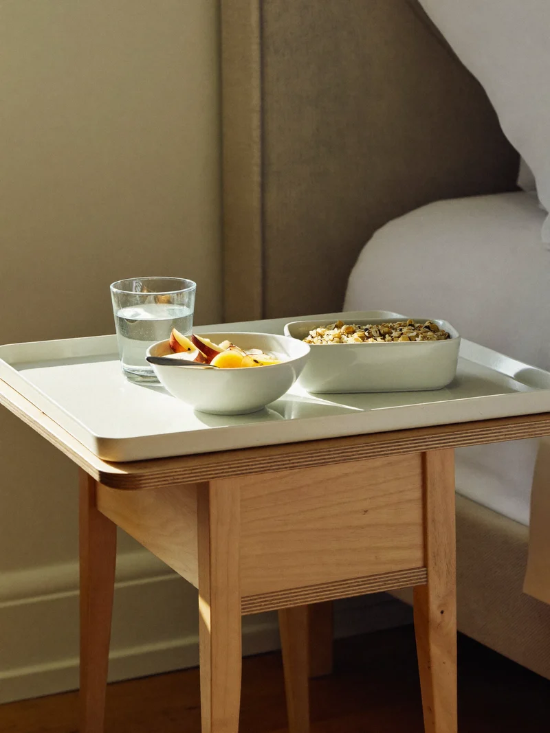 Vassoio della colazione con yogurt, frutta a fette, porridge d'avena e acqua